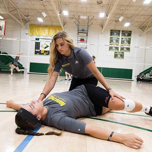 Athletic training student stretching an athlete.